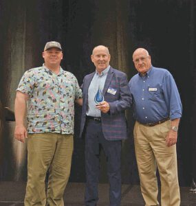 article image - Calusa Waterkeeper Capt. Codty Pierce, left, and Board President Chuck Avery, right, present the Advocate of the Year Award to islander Mike Hannon. PHOTO PROVIDED